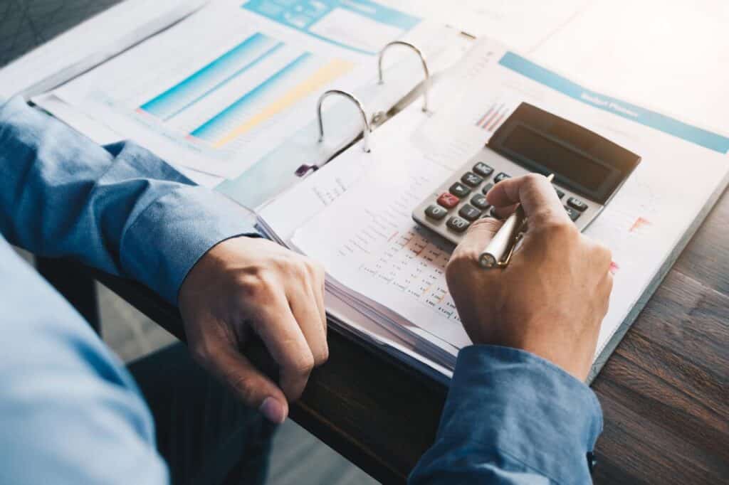 Businessman hand working with financial documents and calculator